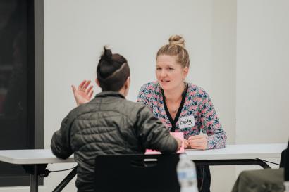 two women-identifying individuals sit at a mentoring event