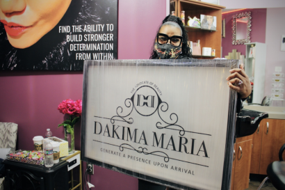 Dakima Maria holds business sign
