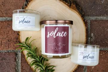Three candles are on display with a label that reads "solace"