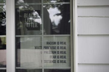 Sign in window reads "racism is real, white privilege is real, oppression is real, fear is real, resistance is real"