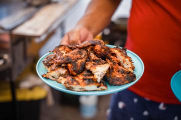 Raymundo holds a plate of perfectly charred chicken