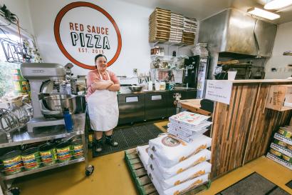 Shardell dues, the owner of red sauce pizza, stands in the shop's kitchen