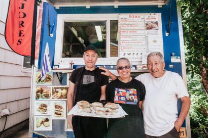 Family of food truck owners stands in front of empanada truck