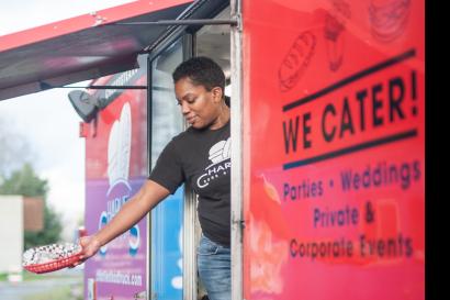 Woman hands food out of the window of a downtown seattle foodtruck