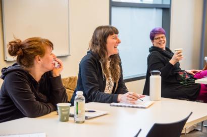 Smiling women sit in business education classroom 