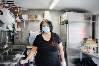 The owner of southern girl delights stands in her food truck kitchen in a black shirt