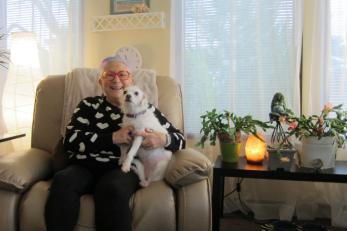 Woman holding small dog in her living room