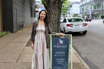 Woman stands in front of her plant shop