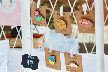 Handmade pins in whimsical shapes such as donuts and dinosaurs