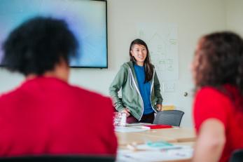 Woman standing in front of a class.