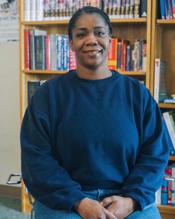 Woman in front of bookshelf