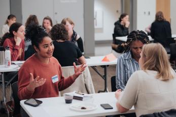 Women talk at a table during a mentoring session