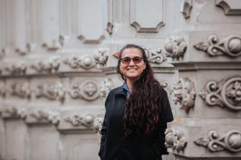 Woman in front of structural columns.