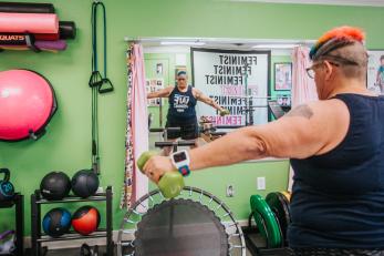 Woman lifting weights in exercise facility.