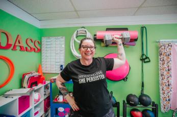 Woman lifting weights in exercise facility.