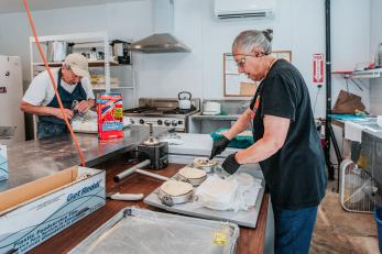 Couple working in kitchen making empanadas.