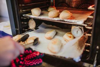 Empanadas being taken from an oven.