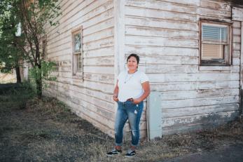 Woman standing in front of old building in warms springs oregon.