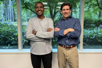 Tim Cooke and Alexis Ruhumuriza stand side-by-side in the office of their business Agape In Home Care