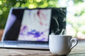 Laptop on table with mug of coffee