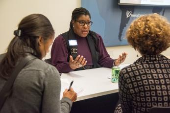 Woman coaches two entrepreneurs at event