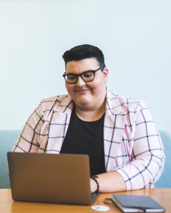 person sits at table on computer