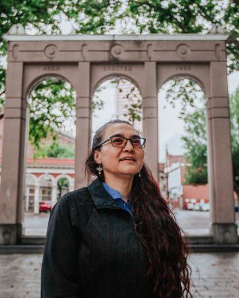 woman stands in downtown Portland posing for a headshot