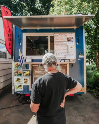 Man stands in front of food truck.