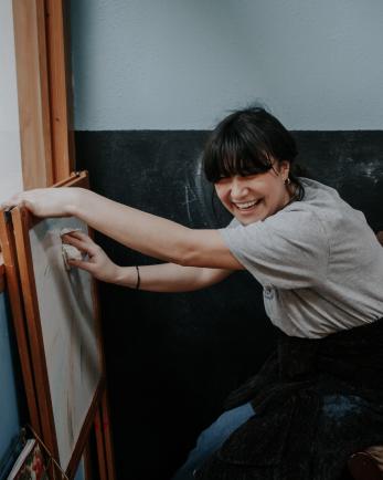 woman smiles while cleaning white board