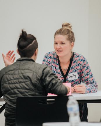 two women-identifying individuals sit at a mentoring event