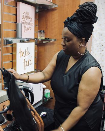 woman in beauty salon holding hair extension