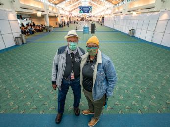 The owners of a small business pose for the camera in portland international airport where their shop is located. 