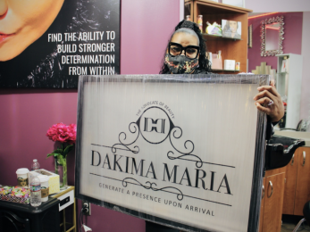 Dakima maria holds business sign